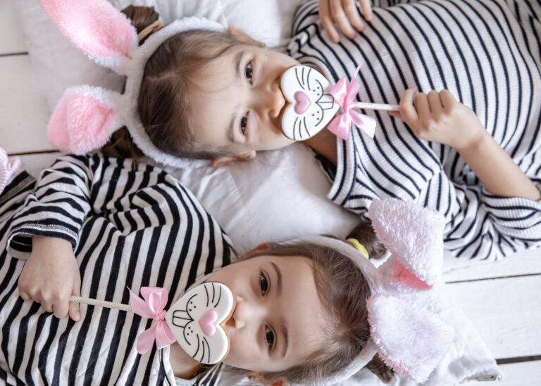 Close up of little girls with Easter gingerbread cookies and in bunny ears.