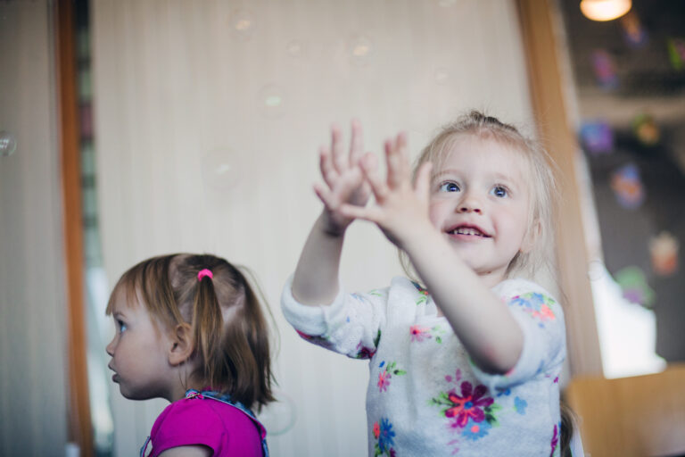 smiling-little-girl-catching-soap-bubbles